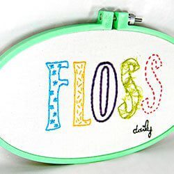a cross stitched saying reminds you to floss daily