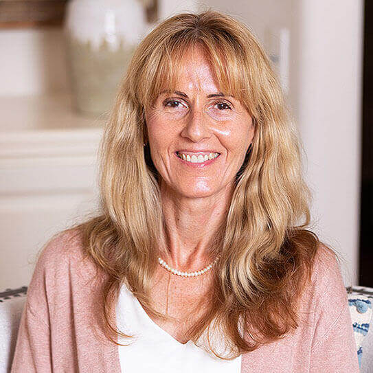a woman smiles after reading the spotlight on women's oral health